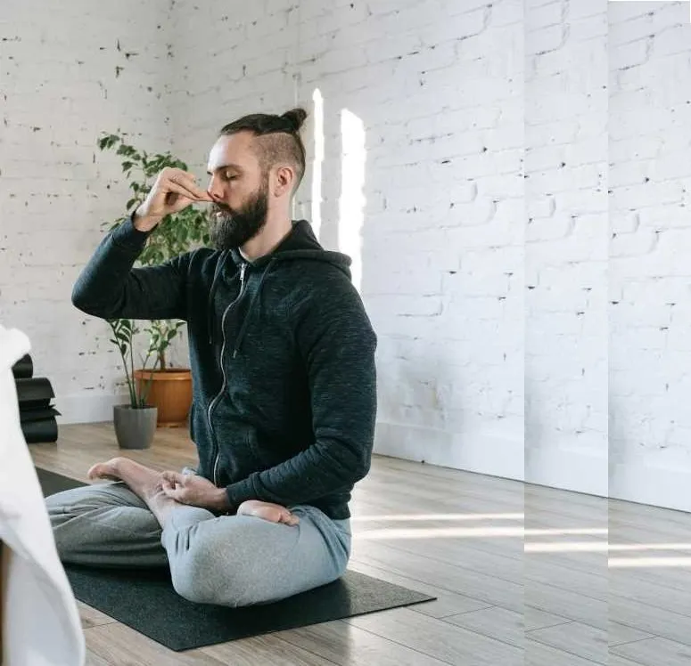 Person seated closing the right nostril to breathe through the left