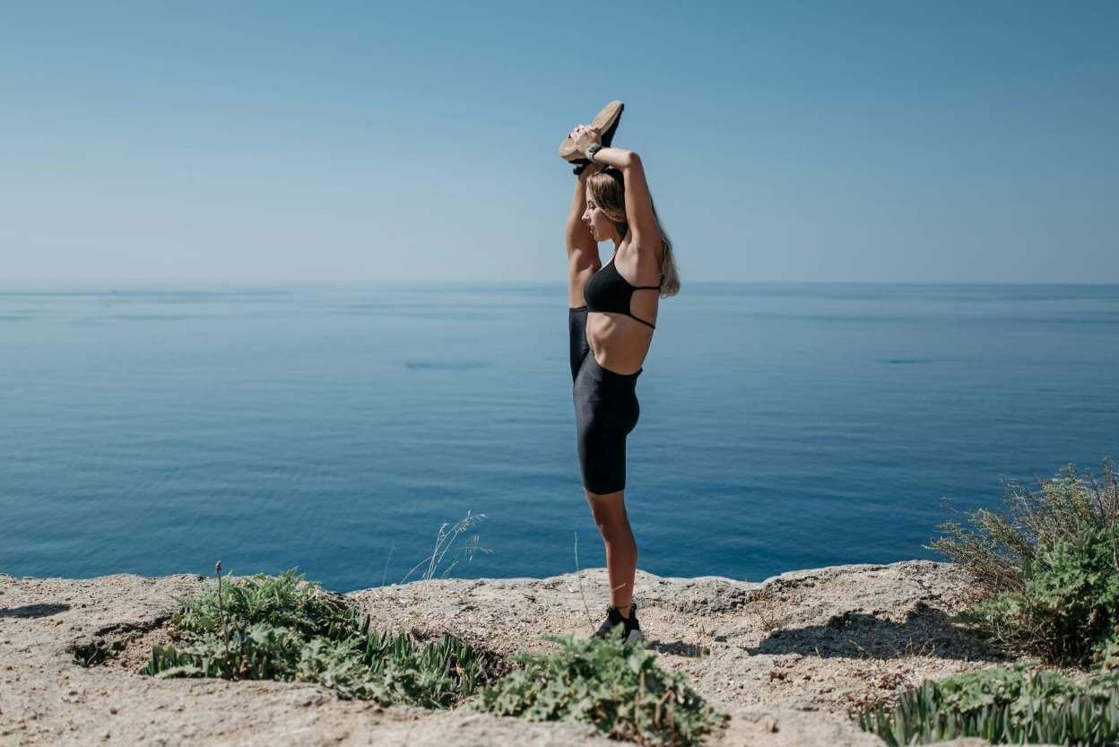 girl stretching leg up to head to get flexibility
